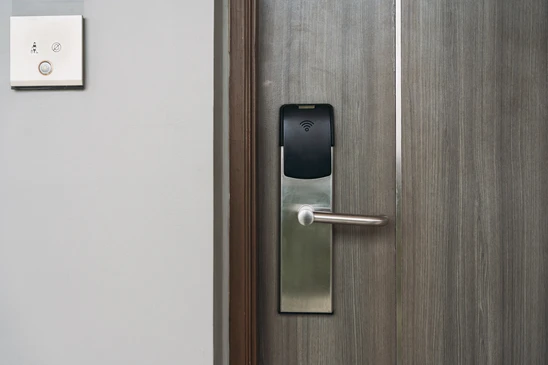 Intérieur résidentiel, technicien installant une serrure électronique sur porte d'entrée